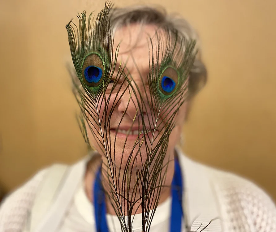 image of ,Mary Long being silly with peacock feathers over her eyes